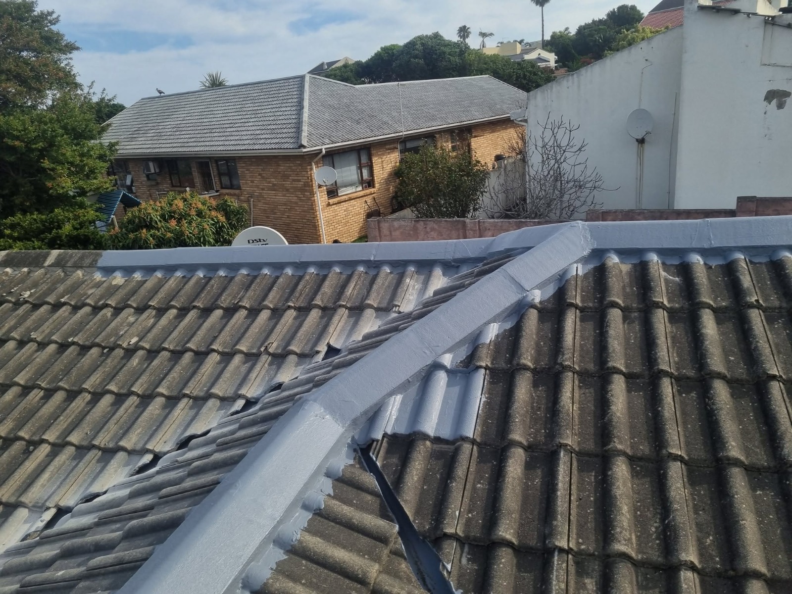 After photo of roof ridge and parapet waterproofed with grey coating