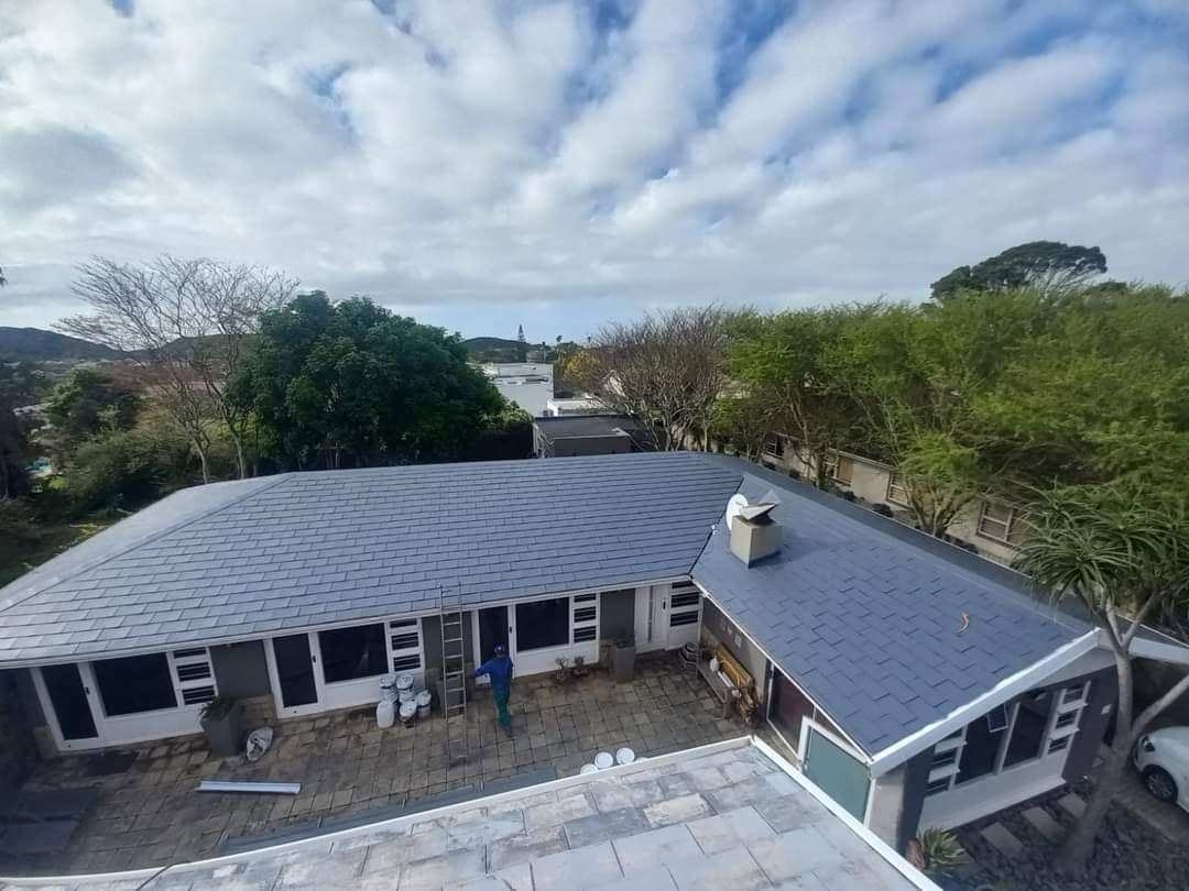 Large completed grey roof rubberising project on a residential property