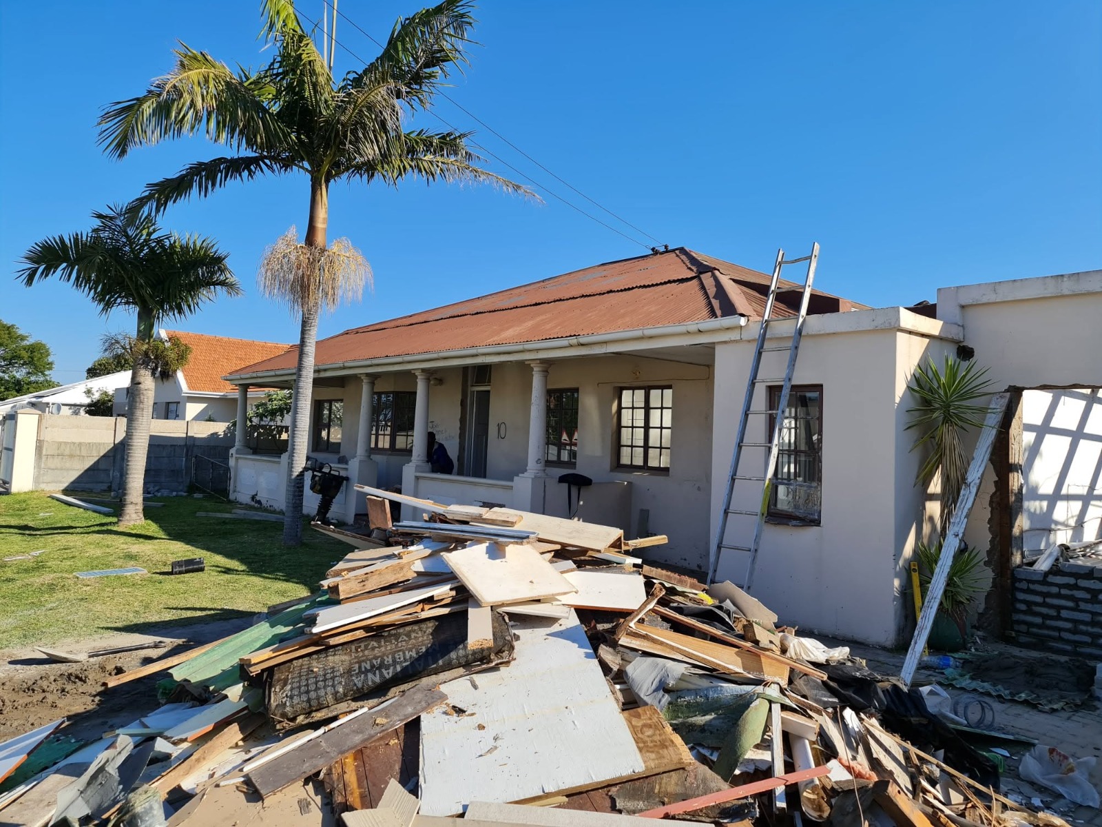 Before re-roofing photo showing old roof and property with repair debris