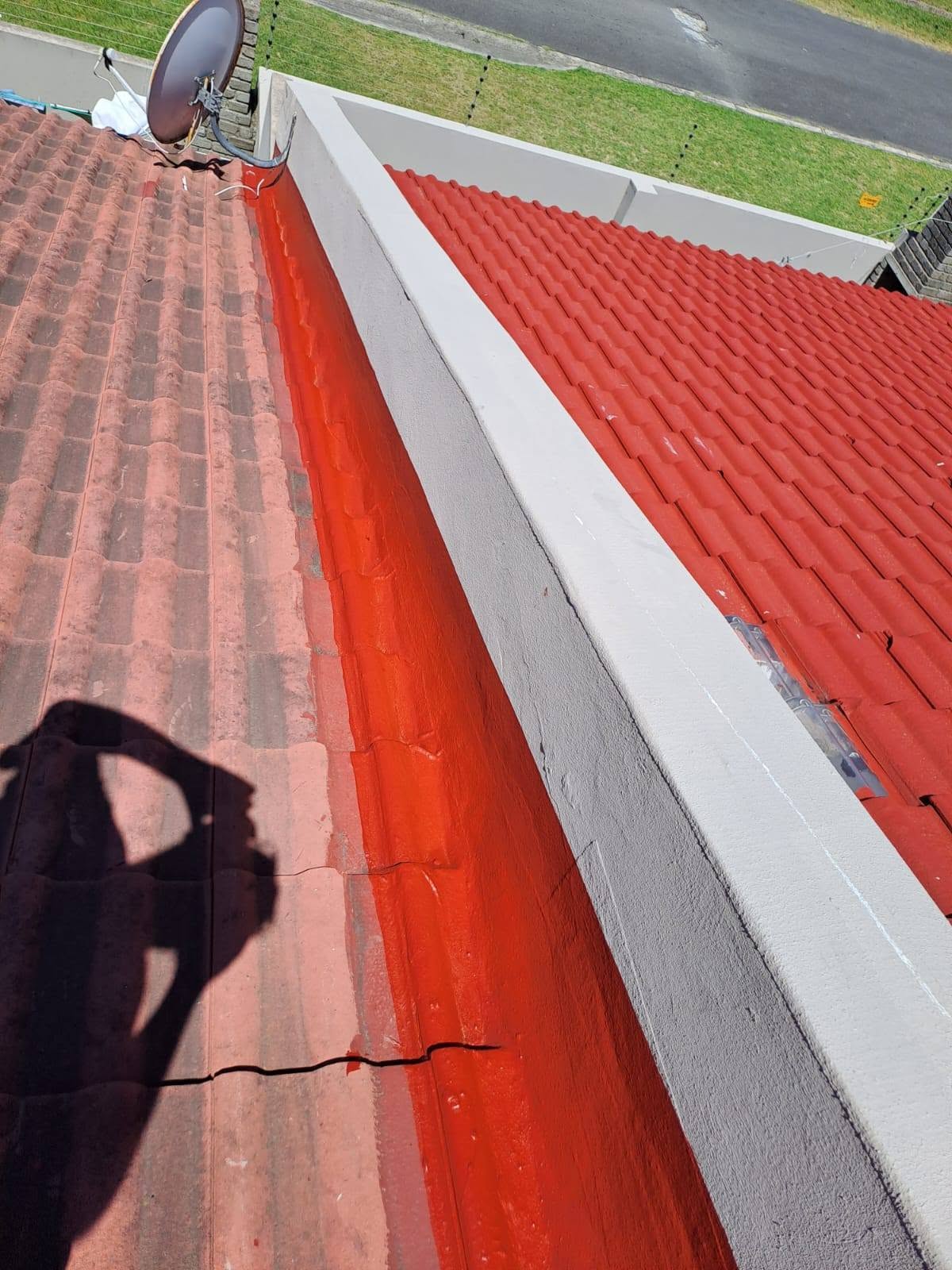 Red waterproofing applied along roof valley and gutter edge area